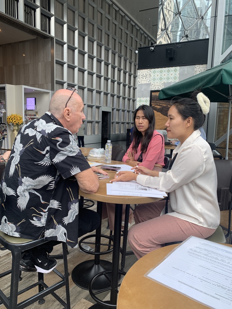 Spoyzy explaining marriage documents to a couple in Bangkok