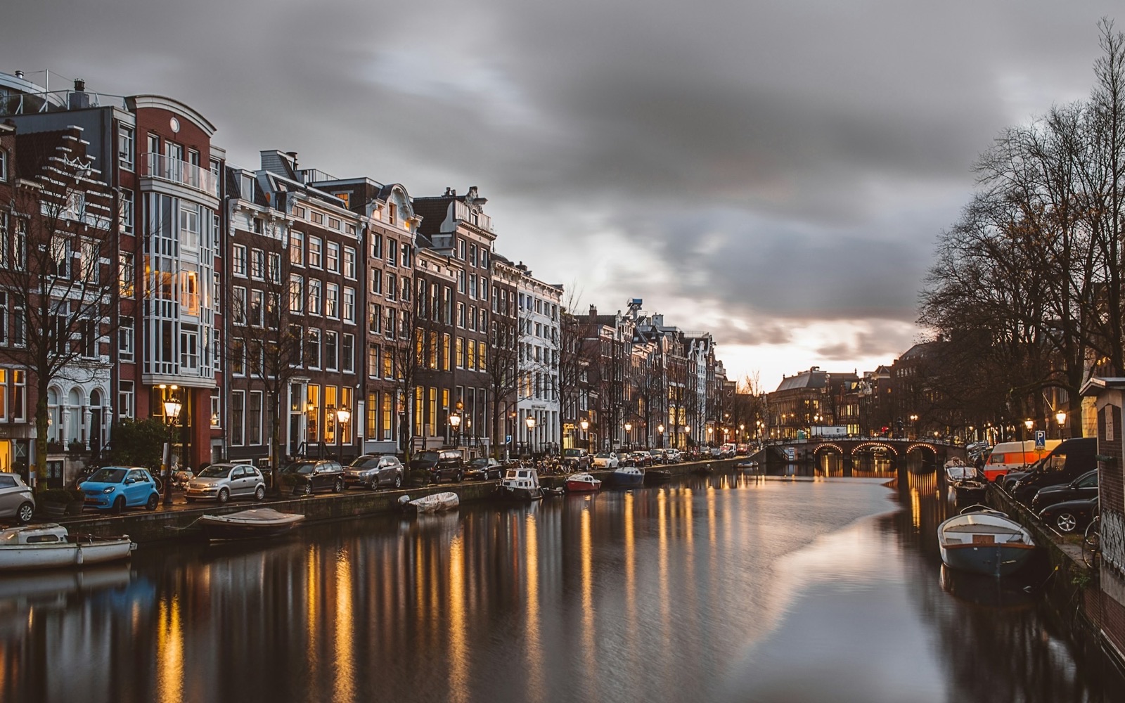 Amsterdam canal houses at dusk Amsterdam canal lined with historic houses at dusk, lights reflecting in the water