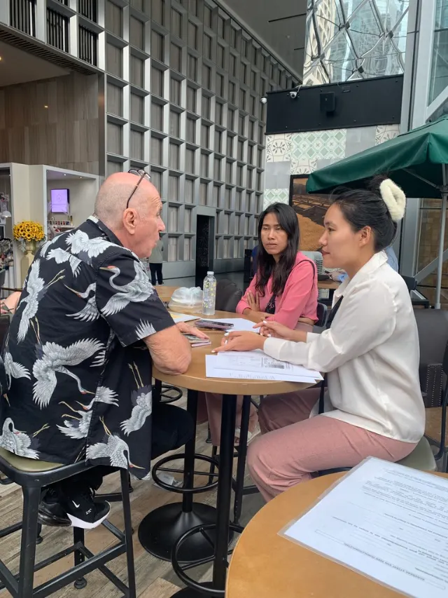 Spoyzy explaining marriage documents to a couple in Bangkok
